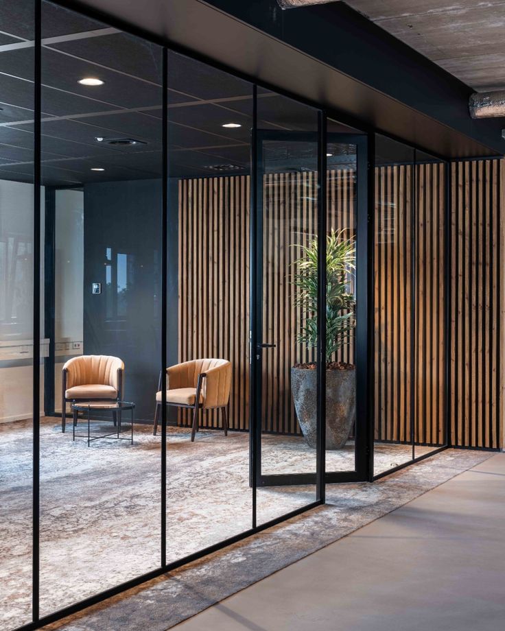 Donkere lounge met cognac stoelen en houten lamellen